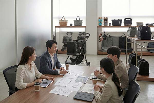 Anvoya team and distribution partners in a strategic meeting, reviewing pet product designs and planning within the showroom.)