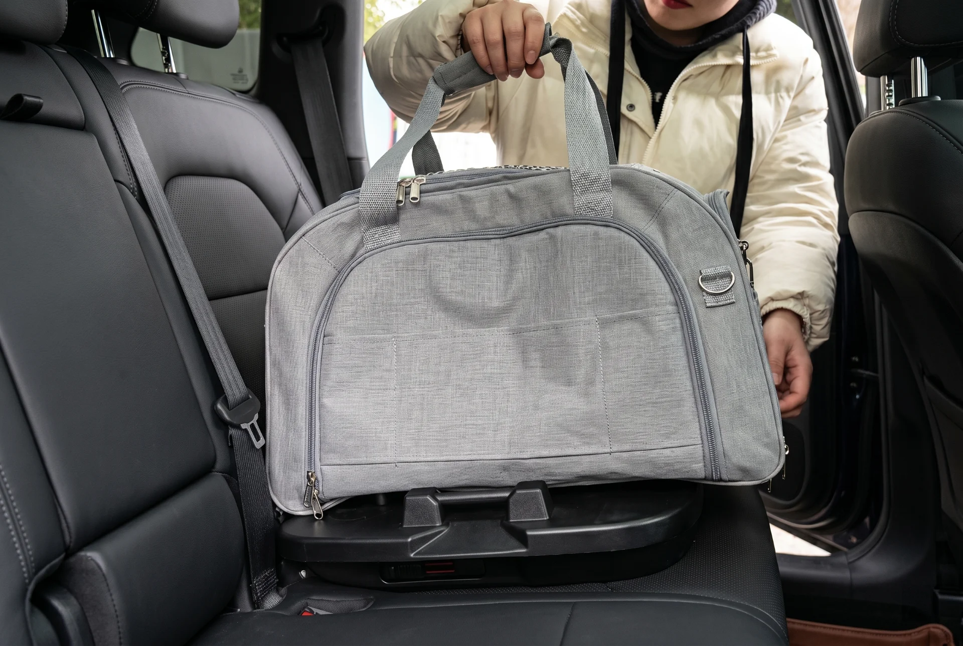 Small pet owner lifting a lightweight carrier from car seat to stroller frame